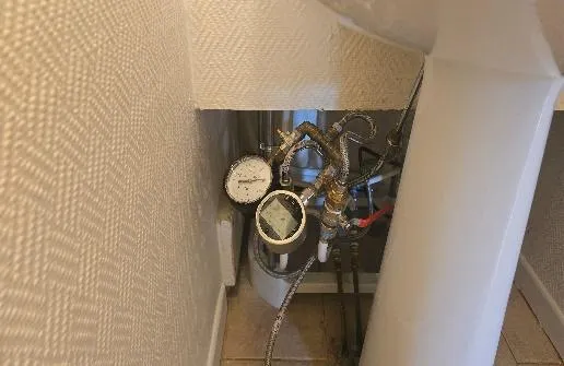 Manomètres et flexibles raccordés à une tuyauterie en laiton dans un recoin de logement